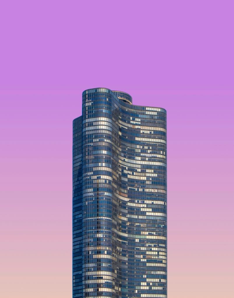 A skyscraper against a purple sky background