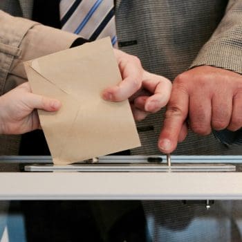 A person putting an envelope into a deposit box