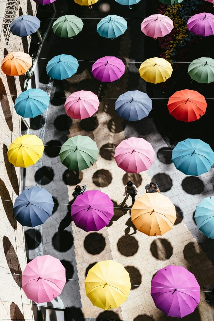 An overhead shot of umbrellas of various colors