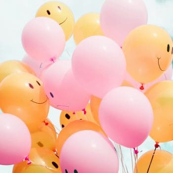 Orange and pink balloons with smiley and frowning faces